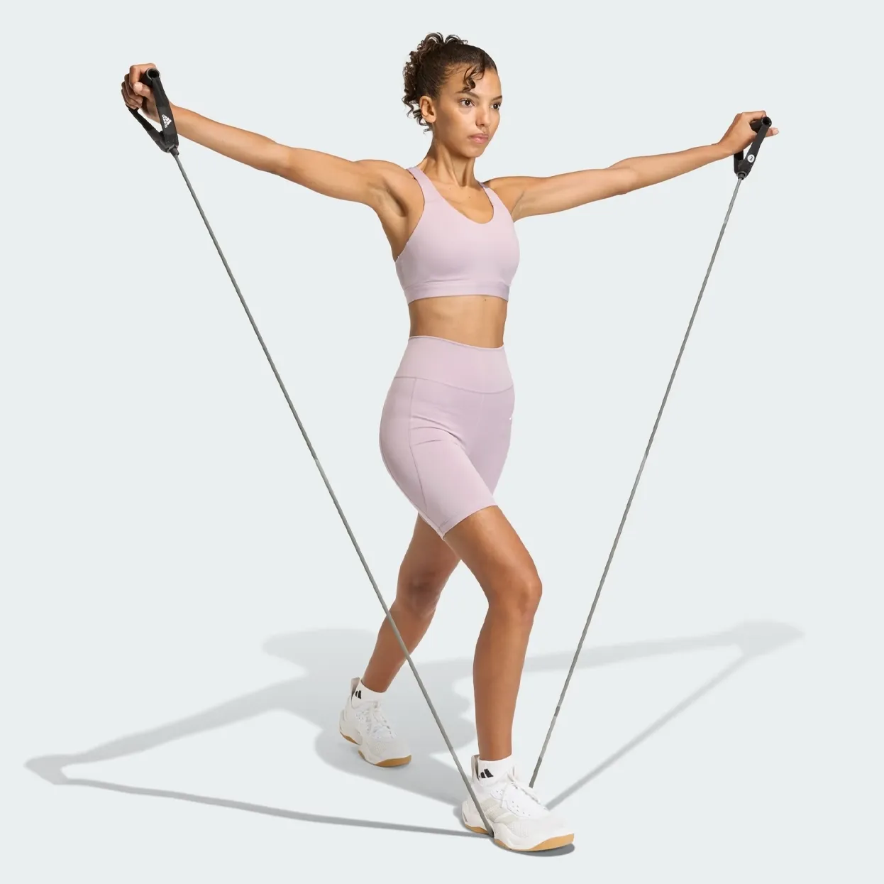 Mulher usando bermuda feminina Adidas rosa durante exercícios
